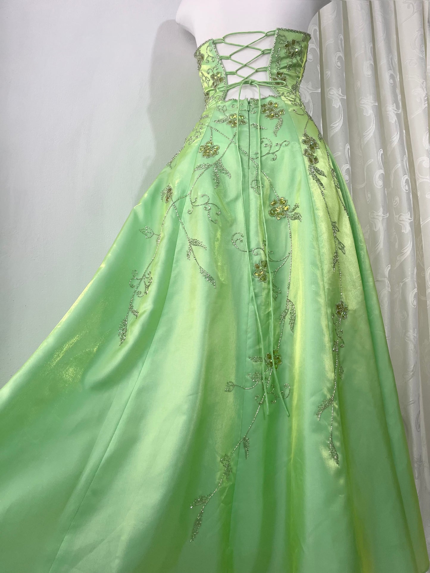 Corset gown dress in a vibrant pistachio green with exquisite handmade raised floral embroidery