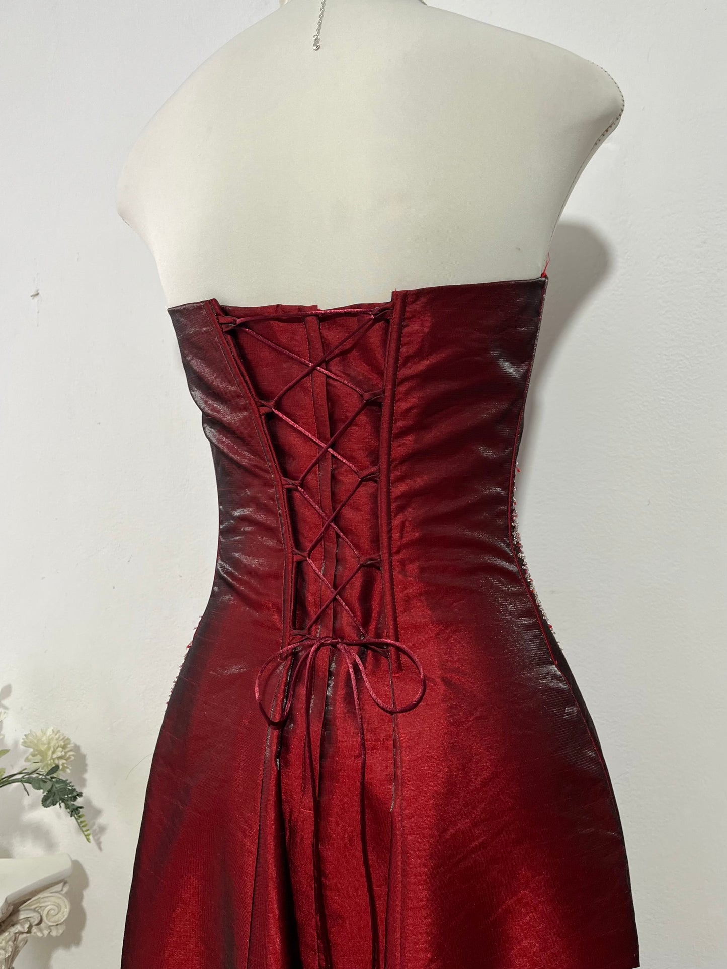 Strapless corset dress in crimson burgundy taffeta with hand-embroidered rhinestones and embellishments